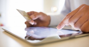 Man using tablet whilst holding bank card